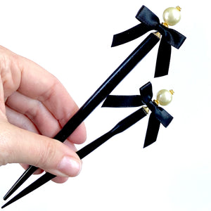 The large and standard sizes of the Audrey hair stick made with ivory glass pearls and black satin bows.