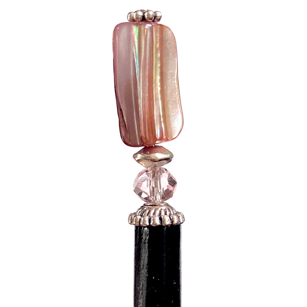A close up of the Eve Tidal Hair Stick made from pink mother of pearl shell beads