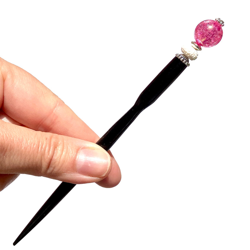 A close up of our Chelsea Hair Stick made with hot pink crackle glass beads