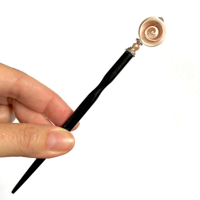 A close up of the Cali Tidal Hair Stick made from a natural shell bead and pearl accent bead.