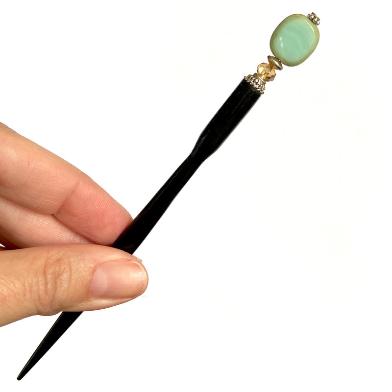 A close up of the Dakota Tidal Hair Stick made from a turquoise Czech glass bead