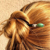 A woman wears a hair bun using the Joanna Tidal Hair Stick made from aqua green aventurine stone beads