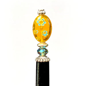 A close up of our Lizzie Tidal Hair Stick made from yellow and blue flowered Czech glass beads. 