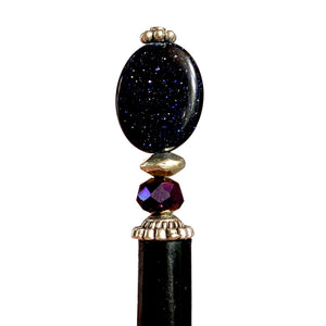 A close up of the Andromeda Tidal Hair Stick made from blue goldstone.