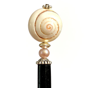 A close up of the Cali Tidal Hair Stick made from a natural shell bead and pearl accent bead.