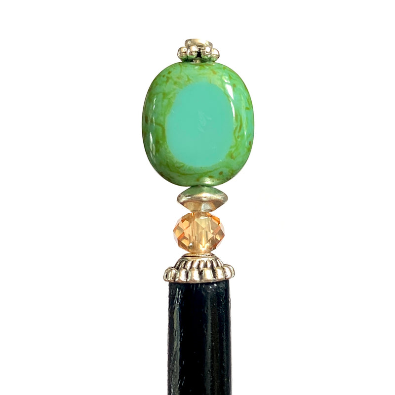 A close up of the Dakota Tidal Hair Stick made from a turquoise Czech glass bead