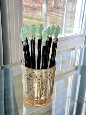 A group of our handmade Remy hair sticks made from oval green swirl Czech glass beads. 
