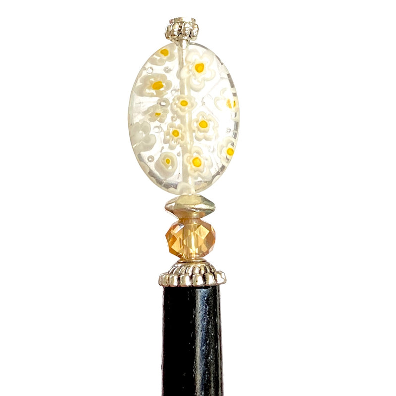 A close up of the Emerson Hair Stick made from transparent white oval Czech glass beads with yellow flowers. 