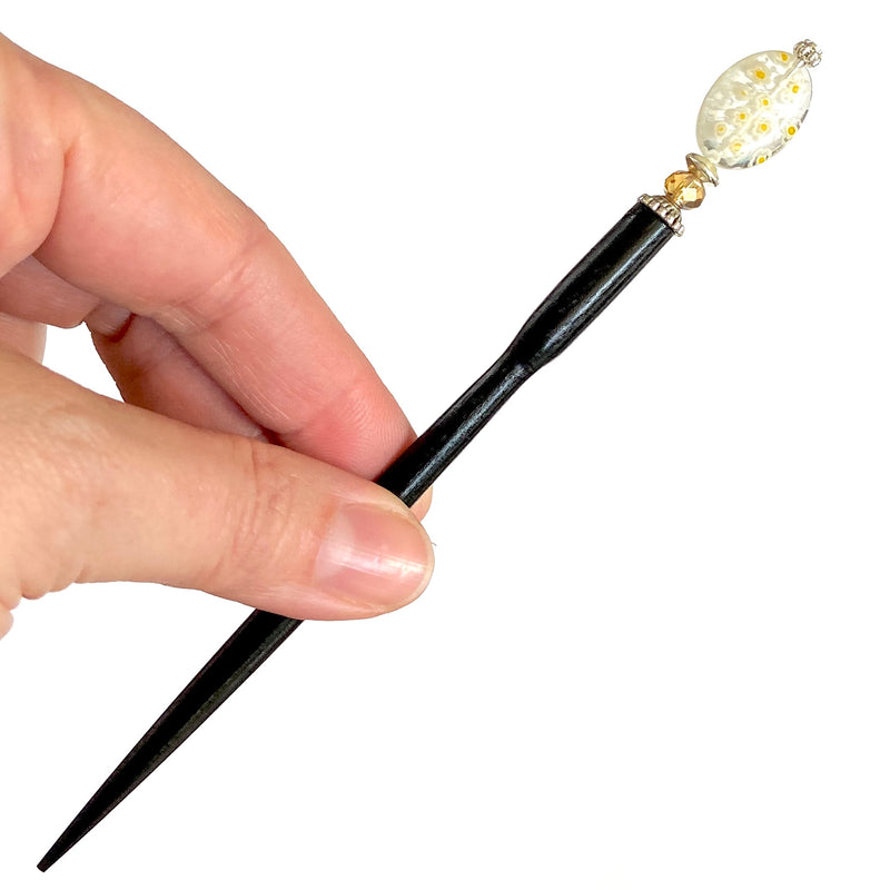 A close up of the Emerson Hair Stick made from transparent white oval Czech glass beads with yellow flowers. 