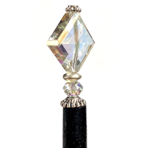 A close up of the Penelope Tidal Hair Stick made from iridescent clear glass beads
