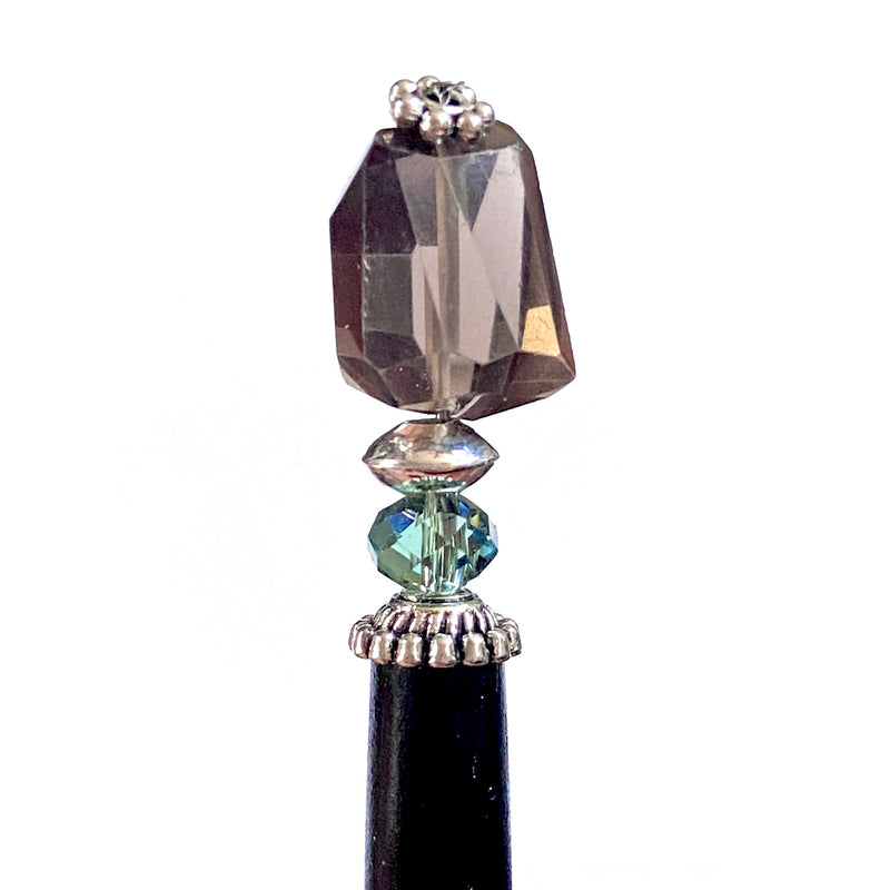 A close up of our Blake Hair Stick made from a brown Smoky Quartz Stone with a Swarovski Erinite Crystal.