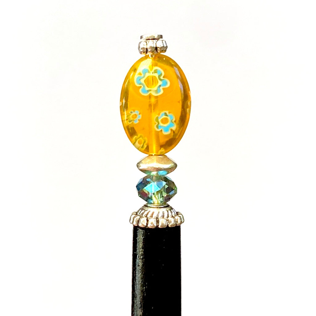 A close up of our Lizzie Tidal Hair Stick made from yellow and blue flowered Czech glass beads. 