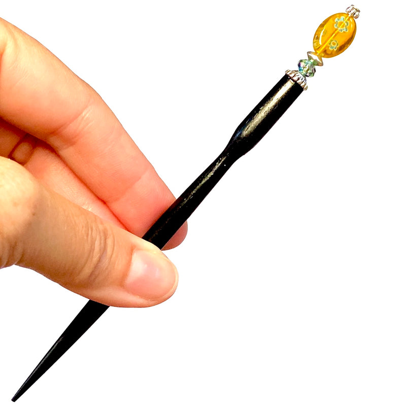 A close up of our Lizzie Tidal Hair Stick made from yellow and blue flowered Czech glass beads. 