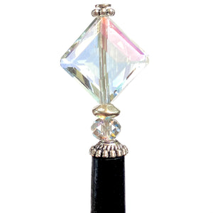 A close up of the Penelope Tidal Hair Stick made from iridescent clear glass beads