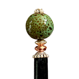 A close up of the Harlow Tidal Hair Stick made from green raku fired ceramic beads.