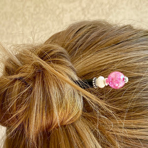 A woman wears one of our Chelsea Hair Stick made with hot pink crackle glass beads