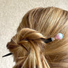 A woman wears one of our Olivia Hair Sticks made from pastel pink and blue acrylic bubblegum beads.