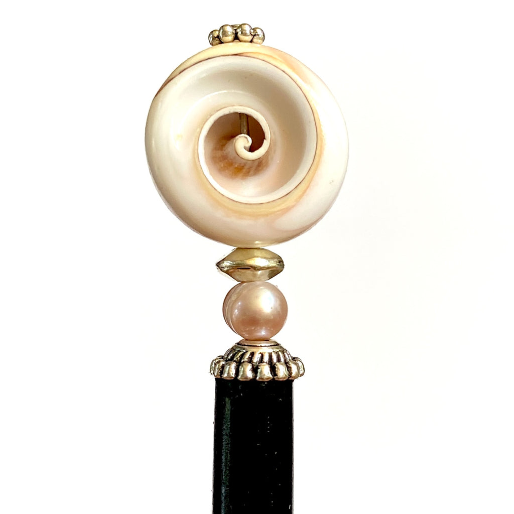 A close up of the Cali Tidal Hair Stick made from a natural shell bead and pearl accent bead.