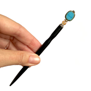 A full shot of the Adelaide Tidal Hair Stick made from blue Czech glass.