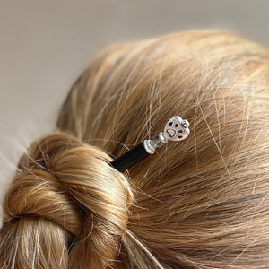 A woman wearing one of our Bailey Hair Stick made with a heart-shaped dog paw print metal bead and Swarovski crystal.