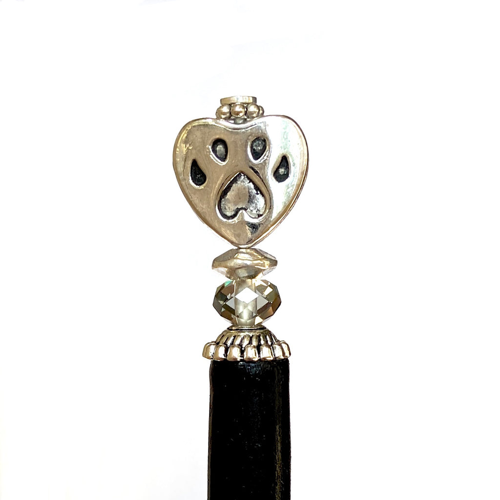 A close up of our Bailey Hair Stick made with a heart-shaped dog paw print metal bead and Swarovski crystal.