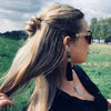 A blonde millennial woman wears a topknot using the Cali Tidal Hair Stick made from a natural shell bead and pearl accent bead