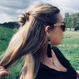 A blonde millennial woman wears a topknot using the Cali Tidal Hair Stick made from a natural shell bead and pearl accent bead