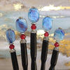 Five of the Charlotte Tidal Hair Stick made from red white and blue swirl glass beads