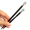The standard and the large sizes of the Charlotte Tidal Hair Stick made from red white and blue swirl glass beads