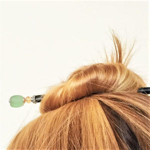 A blonde woman wearing the Daliah Hair Stick made from aqua African Recycled Glass beads.