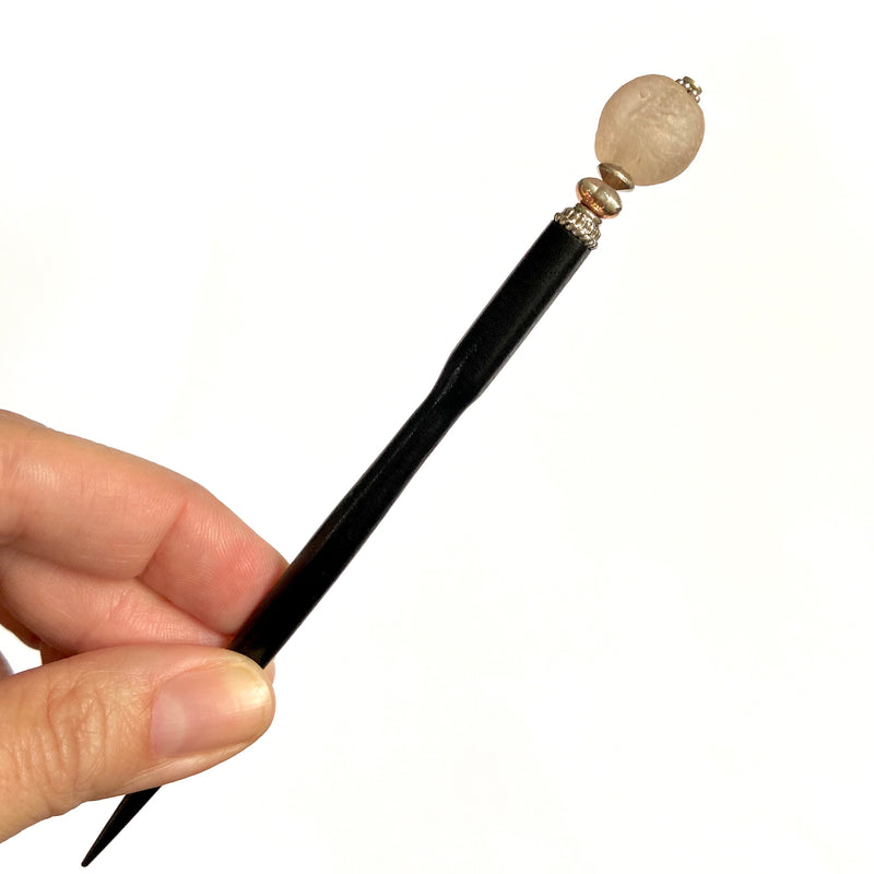 A close up of the Ellen Hair Stick made from blush pink peach African Recycled Glass beads