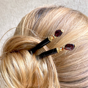 A woman wears two of our Gia hair sticks made from garnet nuggets.