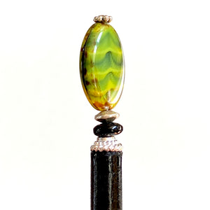 The side view of our Kaja Hair Stick made from green swirl Czech glass beads
