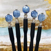 Five of the Kya Tidal Hair Sticks made from blue luster Kyanite stones.