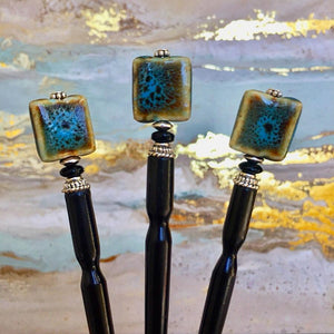 Three of the Lark Tidal Hair Sticks made from square blue raku fired ceramic beads.