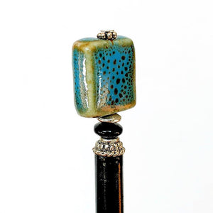 A side view of the Lark Tidal Hair Stick made from square blue raku fired ceramic beads.