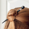 A woman wears one of our Laura Hair Sticks made with Onyx nuggets and Austrian crystal accent.