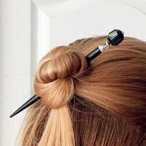 A woman wears one of our Laura Hair Sticks made with Onyx nuggets and Austrian crystal accent.
