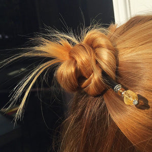 A blonde woman wears a half bun using the Layla Hair Stick made from Yellow Citrine nugget beads.