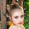 A brunette millennial woman wears a bun using the Luna Tidal Hair Stick made from Rainbow Moonstone nugget beads.