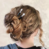 A blonde wearing two Luna Hair Sticks