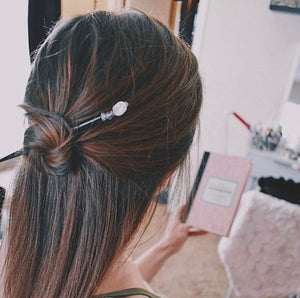 A brunette millennial woman wears a topknot using the Luna Tidal Hair Stick made from Rainbow Moonstone nugget beads.