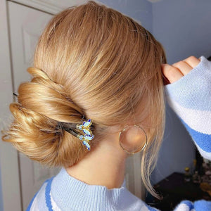 A blonde wonman wears two Mariposa Tidal Hair Sticks