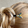 A woman wears one  of the Mariposa Hair Sticks made from cloisonne butterfly beads