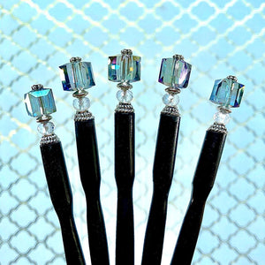 Five of the Marley Tidal Hair Sticks made from iridescent blue glass beads.