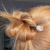 A blonde woman wears one of the Nalina Hair Sticks made from glass flower beads.