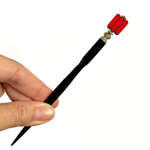 A full shot of the Nela Tidal Hair Stick made from a red Czech glass bead.