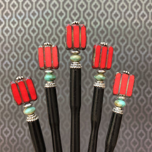 Five of the Nela Tidal Hair Sticks made from a red Czech glass bead.