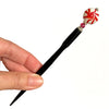 A full picture of our Noelle Hair Stick made from a glass bead that looks like peppermint candy.