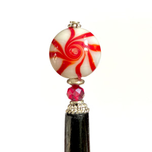 A close up of our Noelle Hair Stick made from a glass bead that looks like peppermint candy.